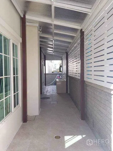 Detached House for sale in Bueng Kum, Bangkok - Covered side walkway with tiled floor and white privacy slats.