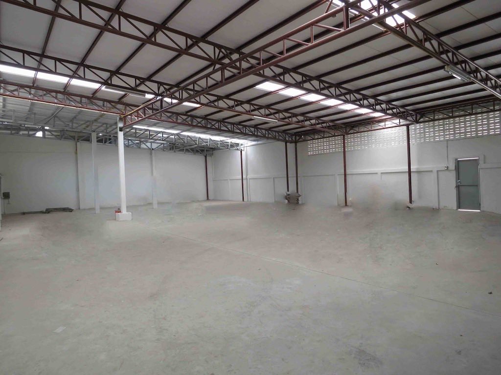 Warehouse for rent in Wang Thonglang, Bangkok - Spacious clear-span warehouse floor with steel truss roof and skylights.