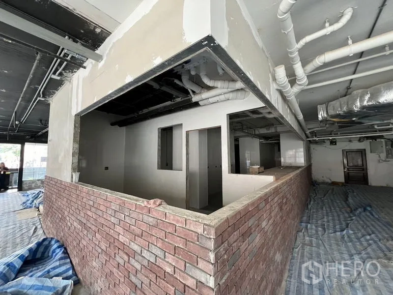 零售空间 出租在Watthana, Bangkok - 室内毛坯带砖砌吧台与裸露管线，适合改造为商用。