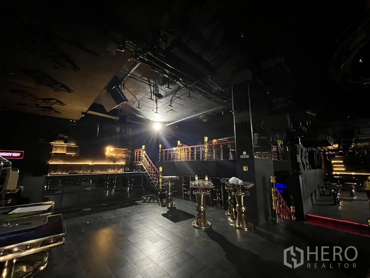 零售空间 出租 - 开放活动区，带吧台置物架、抬高平台与金属栏杆。