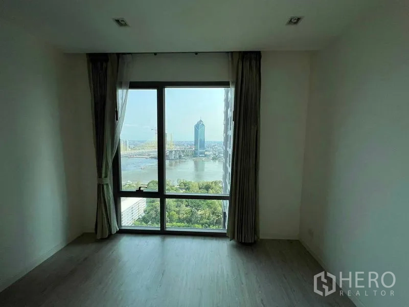 Condominium for sale - Empty room with large window and sweeping river and landmark tower views.