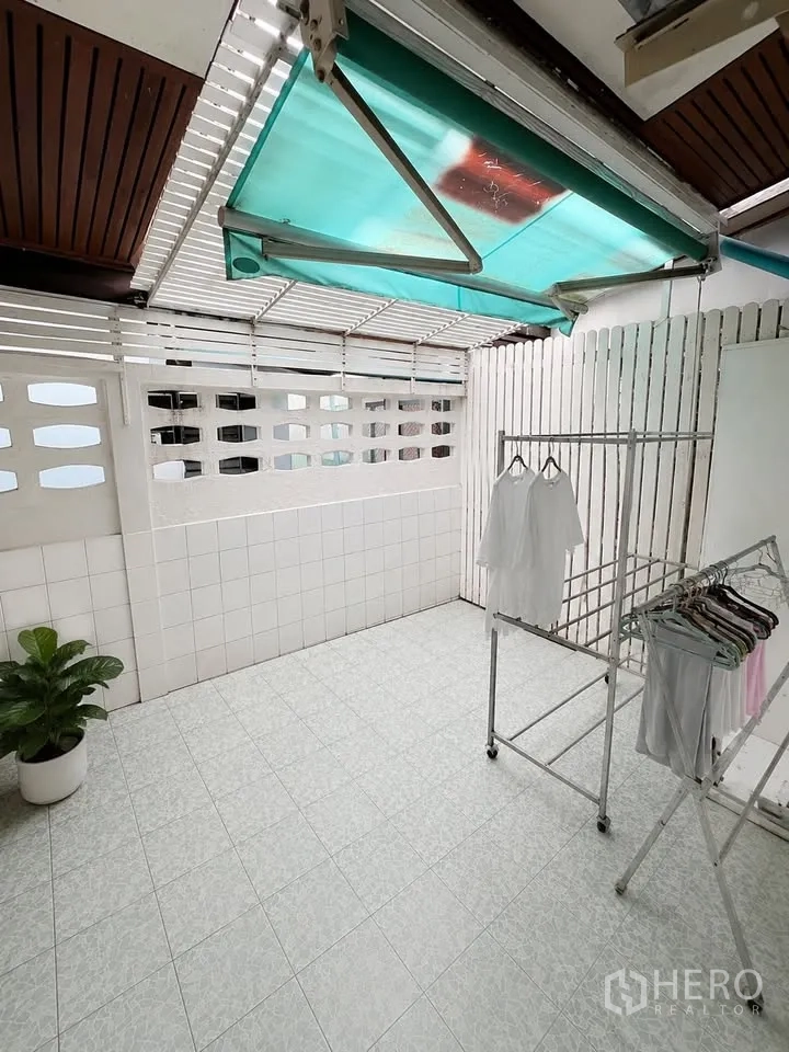 Detached House for rent in Prawet, Bangkok - Covered laundry patio with tiled walls, drying racks and retractable awning.