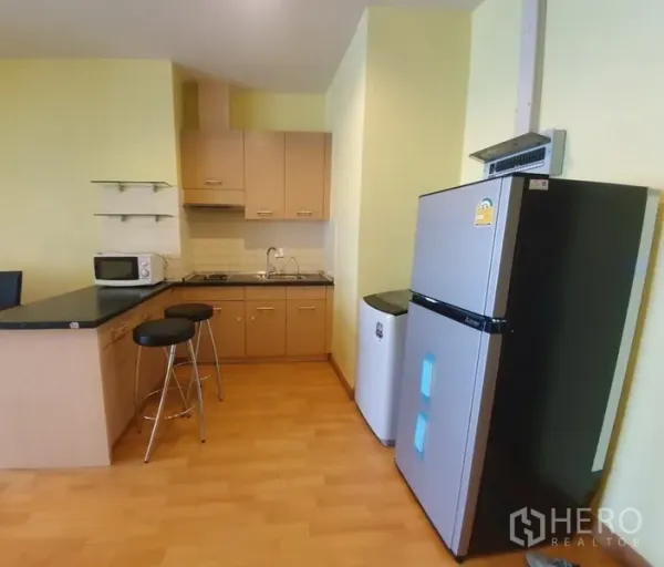 คอนโด ให้เช่าในKhlong Toei, Bangkok - ครัวเปิดพร้อมเคาน์เตอร์บาร์ ตู้เย็น ไมโครเวฟ ตู้เก็บของ และเตา