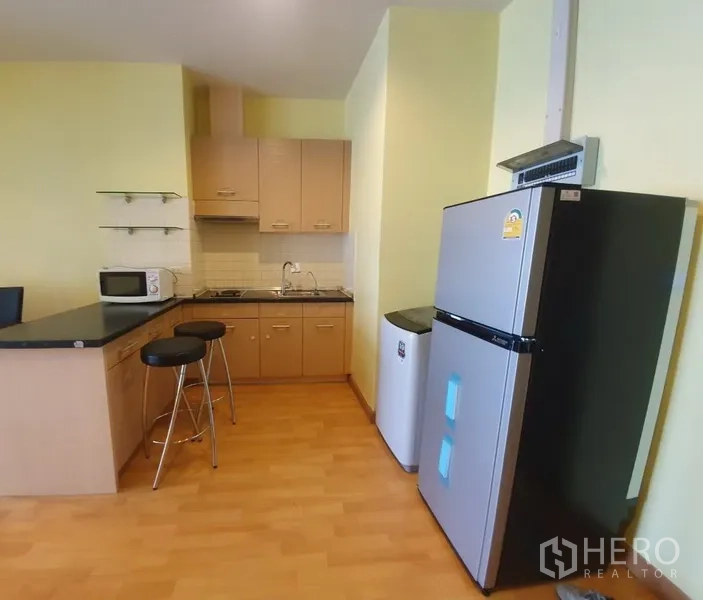 คอนโด ให้เช่าในKhlong Toei, Bangkok - ครัวเปิดพร้อมเคาน์เตอร์บาร์ ตู้เย็น ไมโครเวฟ ตู้เก็บของ และเตา