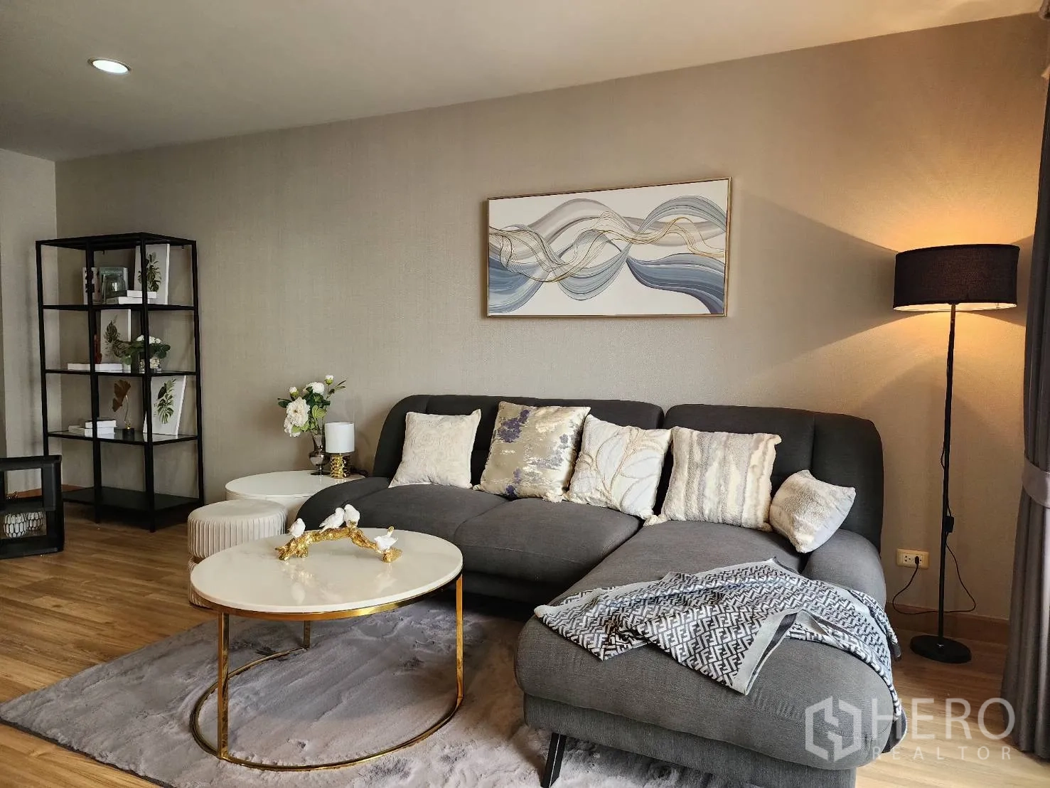 Condominium for rent in Watthana, Bangkok - Cozy living room with gray sectional sofa, round coffee tables and floor lamp.