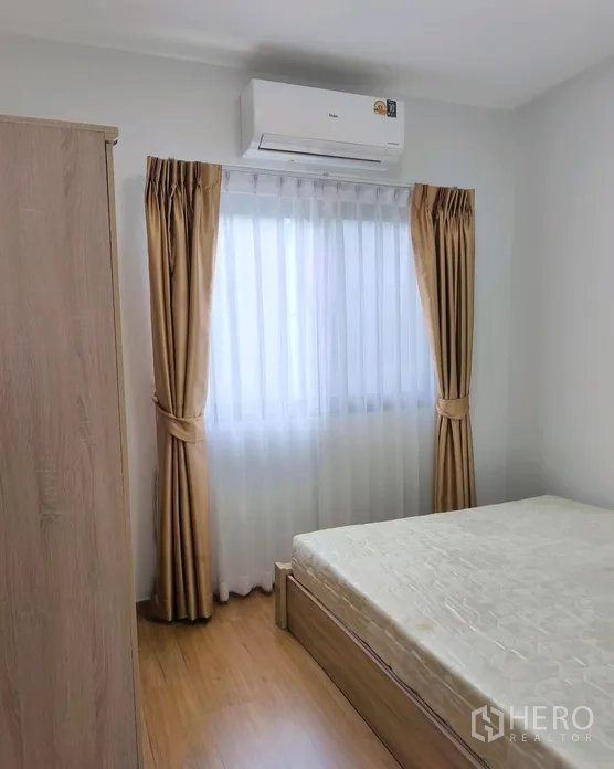 Townhouse for rent in Bang Phli, Samut Prakan - Compact bedroom with bed and wardrobe next to a window.