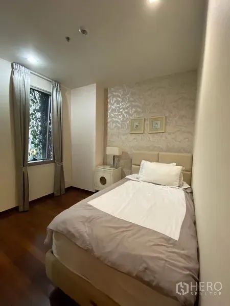 公寓 出租在Khlong Toei, Bangkok - 次卧带单人床与纹理特色墙，采光柔和舒适。