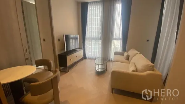 Condominium for rent - Another angle of the living room with sofa, media console, glass table and floor-to-ceiling curtains.