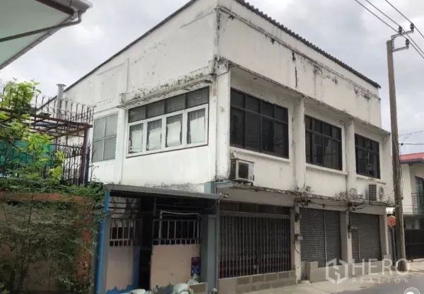 ที่ดิน ขายในPhra Khanong, Bangkok - ด้านหน้าสิ่งปลูกสร้างสองชั้นสภาพเดิมพร้อมประตูม้วนและหน้าต่างบานใหญ่ เหมาะต่อการพัฒนาใหม่.