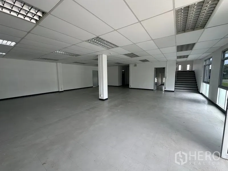 工厂 出租在Pathum Thani - 一层办公室大堂，楼梯与落地窗。