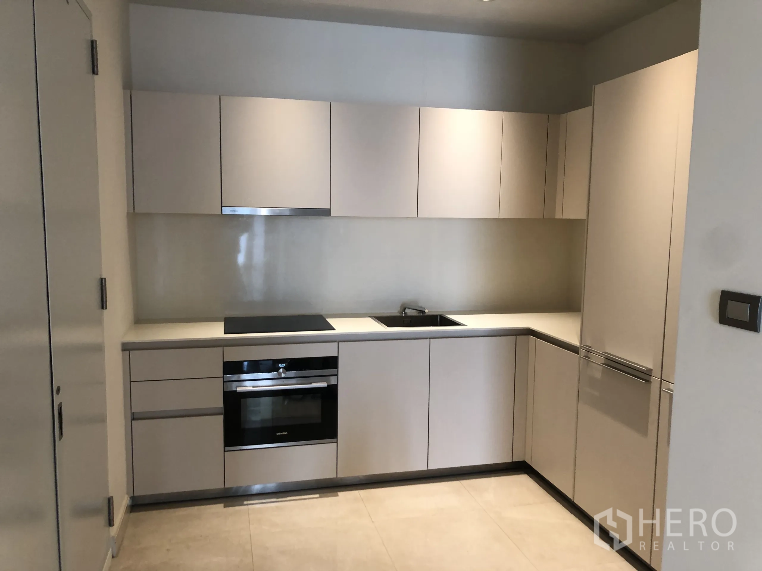 คอนโด ให้เช่าในPathum Wan, Bangkok - ครัวรูปตัวแอลสมัยใหม่ มีเตาไฟฟ้า เตาอบ และตู้เย็นบิวท์อิน.