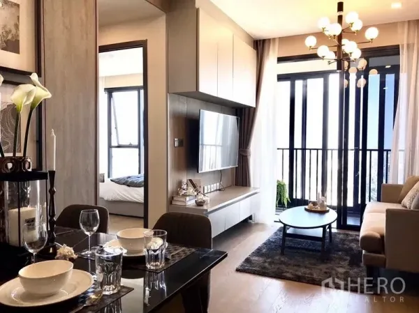 คอนโด ให้เช่าในWatthana, Bangkok - ห้องนั่งเล่นและรับประทานอาหารสว่าง กำแพงทีวี โคมไฟ และระเบียงในคอนโดอโศก