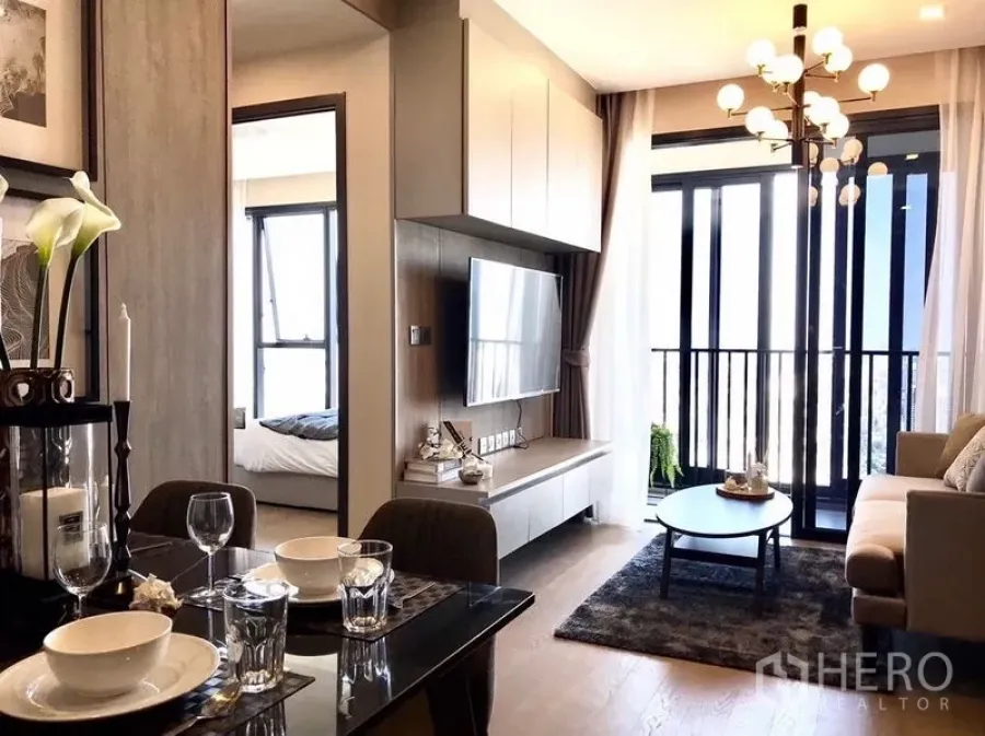 คอนโด ให้เช่าในWatthana, Bangkok - ห้องนั่งเล่นและรับประทานอาหารสว่าง กำแพงทีวี โคมไฟ และระเบียงในคอนโดอโศก