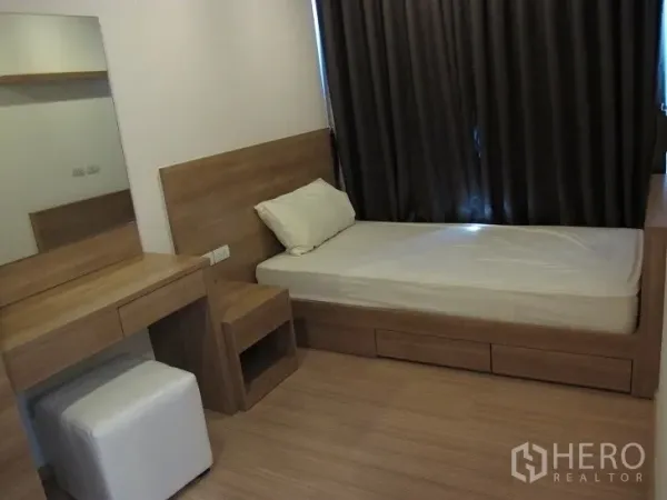 公寓 出租或出售在Khlong Toei, Bangkok - 次卧配单人床、梳妆台与木质饰面，遮光窗帘。