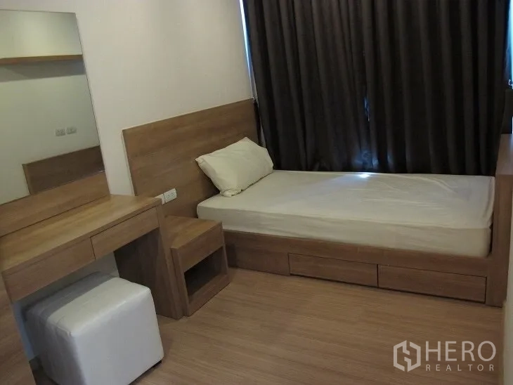 公寓 出租或出售在Khlong Toei, Bangkok - 次卧配单人床、梳妆台与木质饰面，遮光窗帘。