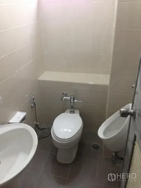 สำนักงาน ให้เช่าในBang Kapi, Bangkok - ห้องน้ำกะทัดรัดพร้อมโถสุขภัณฑ์ โถปัสสาวะ อ่างล้างมือ และผนังกระเบื้องโทนกลาง.