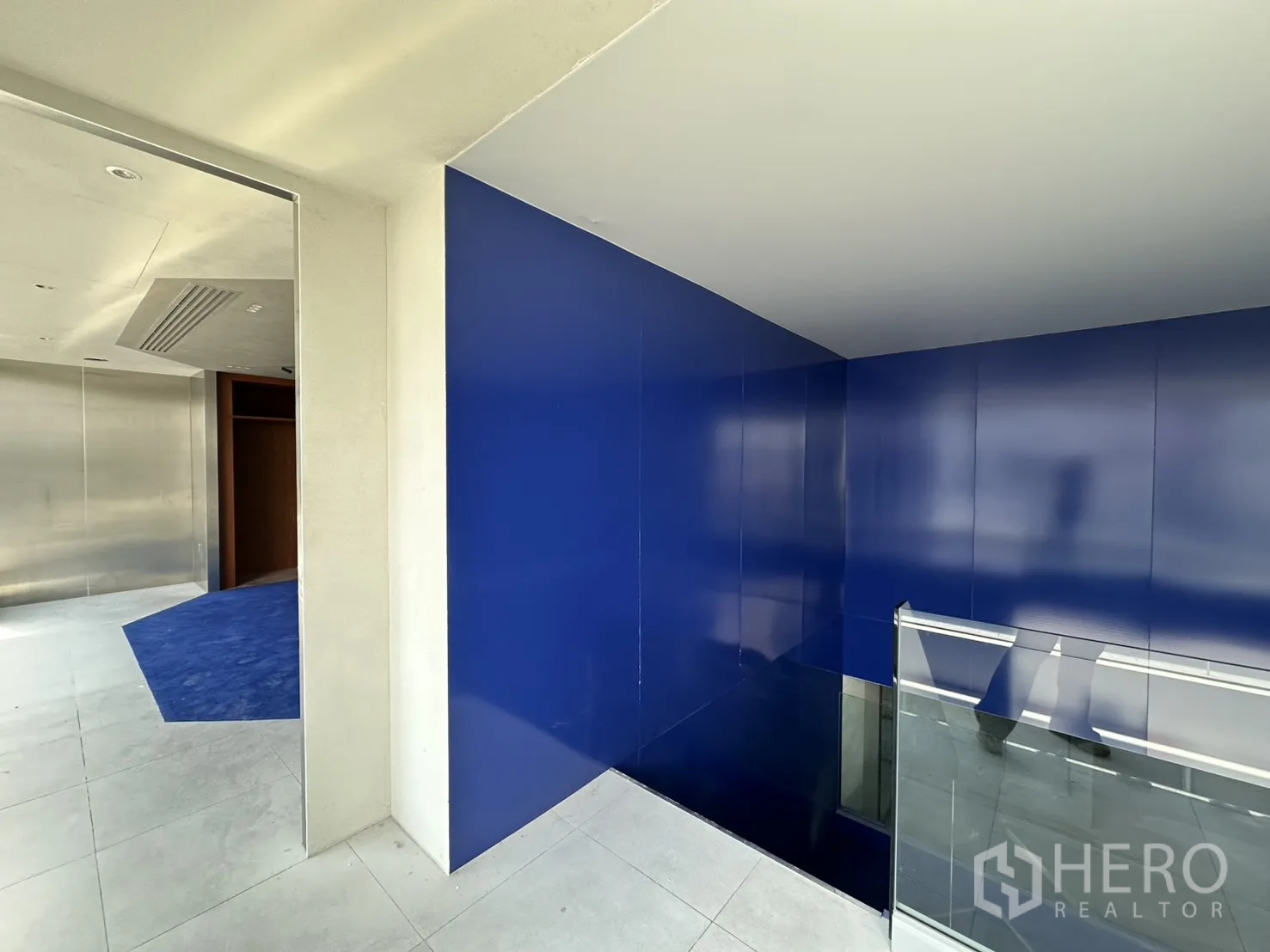 Retail Space for rent in Watthana, Bangkok - Landing with glossy blue wall panels and a glass railing overlooking the stairs.
