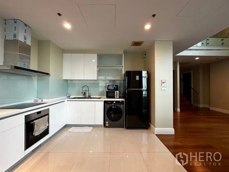 คอนโด ให้เช่าในKhlong Toei, Bangkok - ครัวโทนขาวทันสมัยพร้อมเตาอบ เตาไฟฟ้า เครื่องซักผ้า และตู้เย็นสีดำ