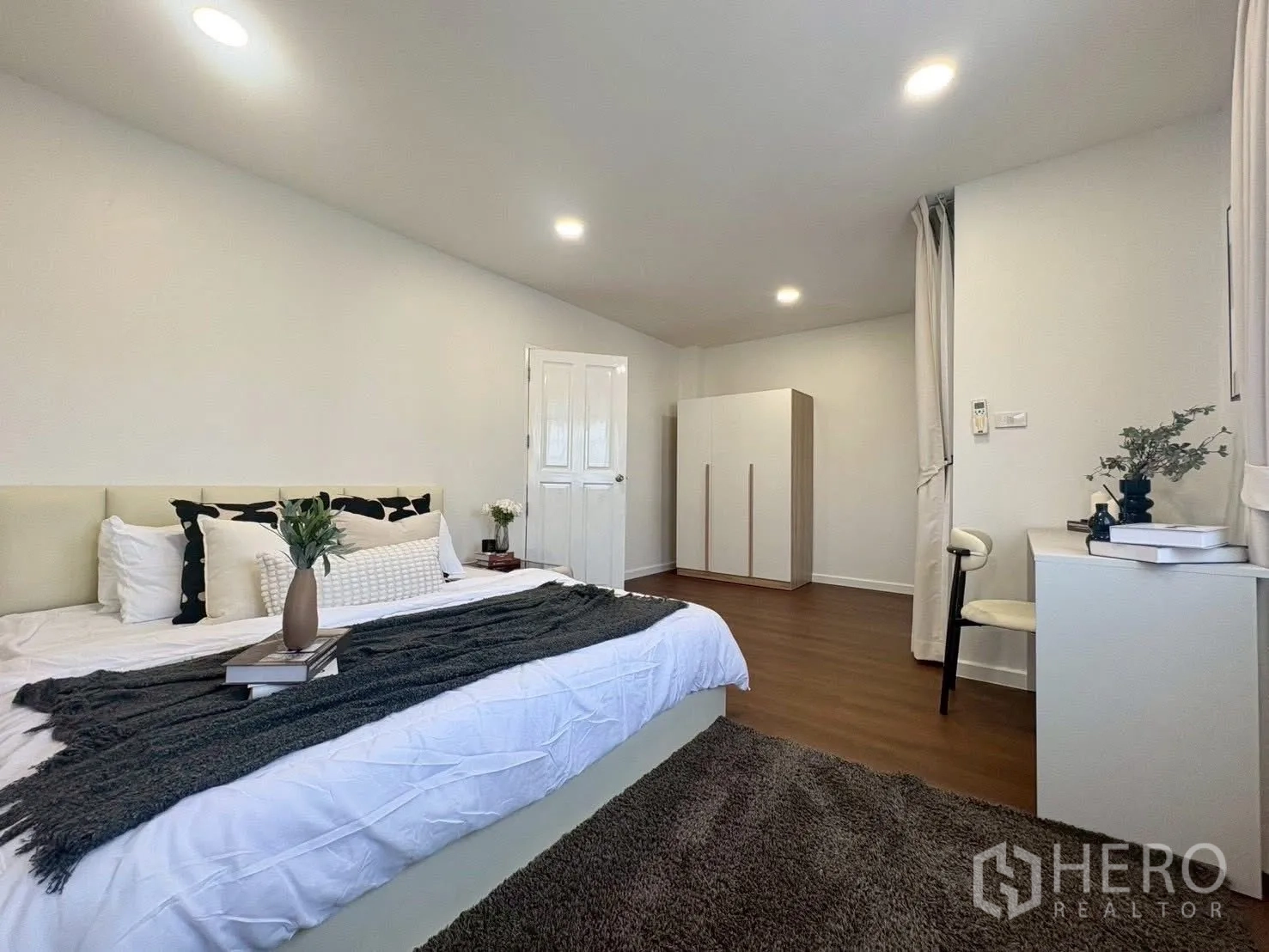 联排别墅 for rent in Huai Khwang, Bangkok - 宽敞主卧，带衣柜、书桌与木纹地面。