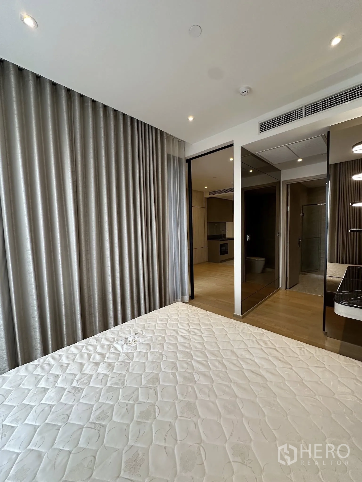 คอนโด for sale in Din Daeng, Bangkok - มุมห้องนอนพร้อมผ้าม่านยาวเต็มบาน ประตูกระจกบานเลื่อนสู่ห้องนั่งเล่น และตู้เสื้อผ้าบานกระจก