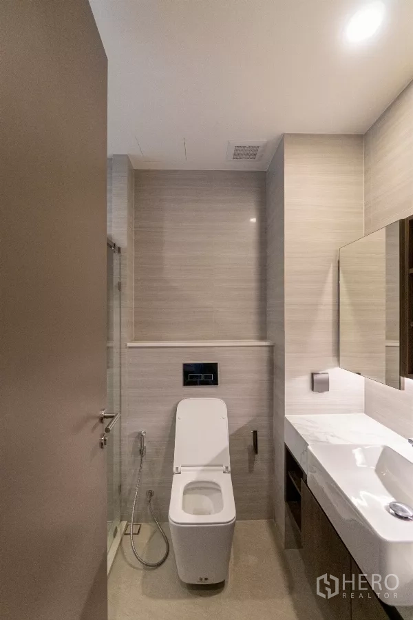 公寓 出租在Watthana, Bangkok - 浴室另一角，现代坐便与长台面洗手盆。