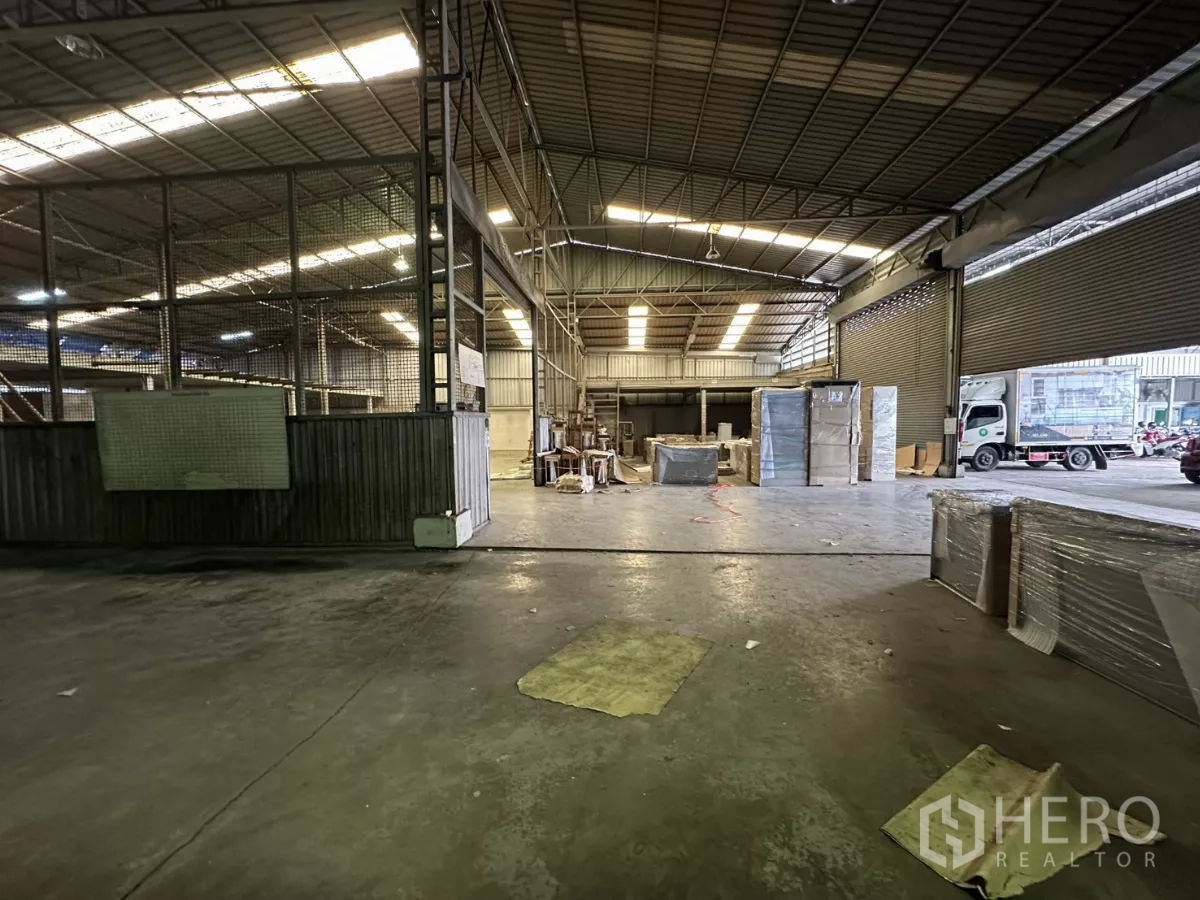 คลังสินค้า ให้เช่าในYan Nawa, Bangkok - มุมมองไปยังลานโหลดสินค้ากว้าง มีประตูม้วนและรถส่งของจอดอยู่