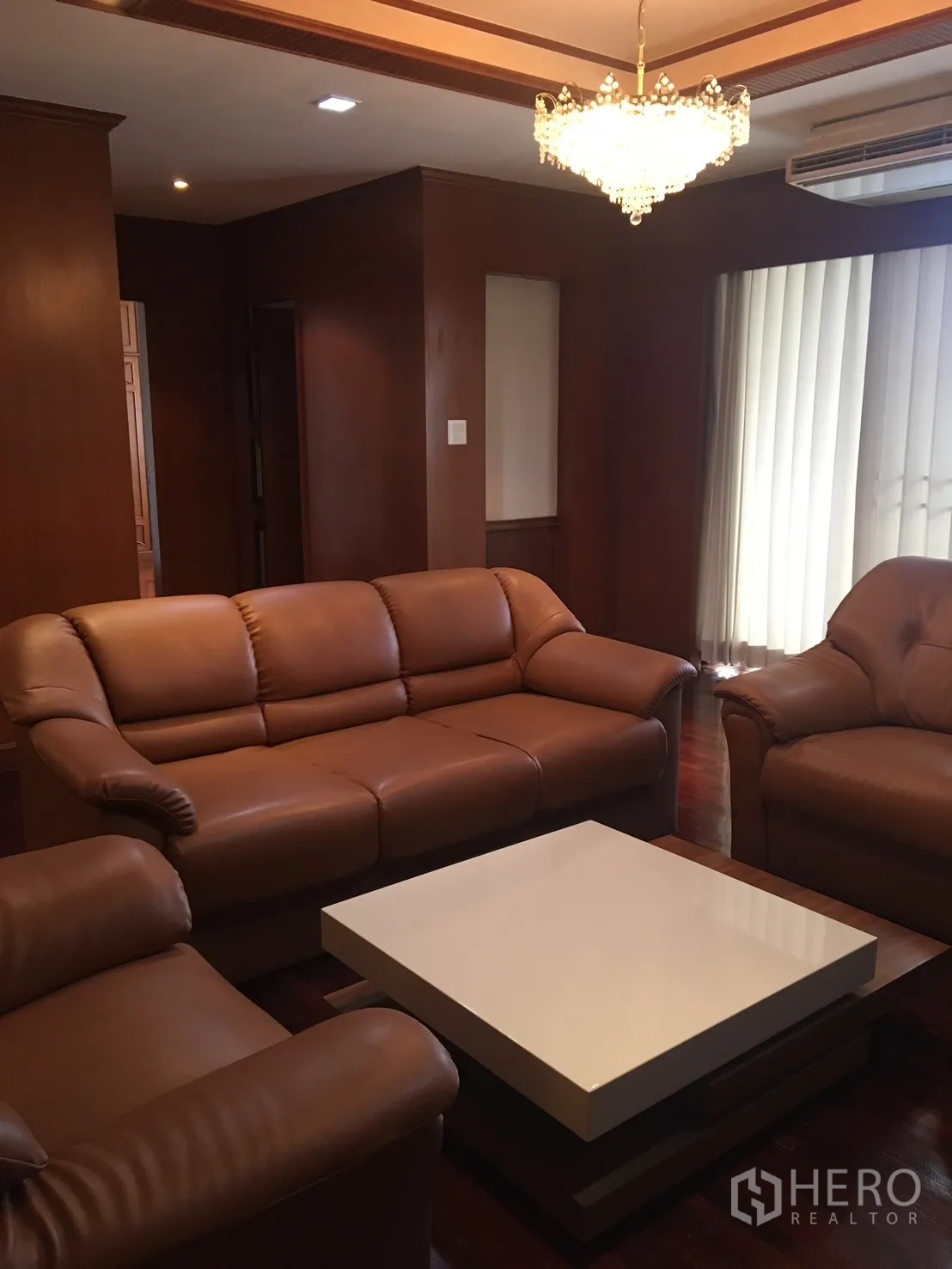 คอนโด ให้เช่าในWatthana, Bangkok - มุมพักผ่อนพร้อมชุดโซฟา โต๊ะกลางสมัยใหม่ ใต้โคมระย้าและม่านบังแสงแนวตั้ง