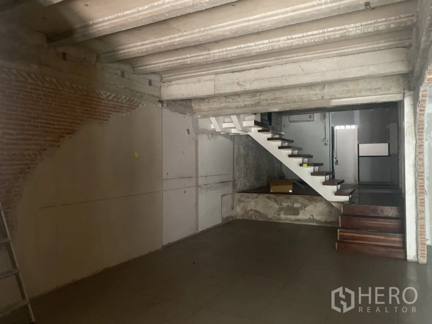 พื้นที่ขายปลีก ให้เช่าในKhlong Toei, Bangkok - พื้นที่ค้าปลีกสไตล์อินดัสเทรียล พร้อมบันไดลอยสีขาวและเพดานคอนกรีต