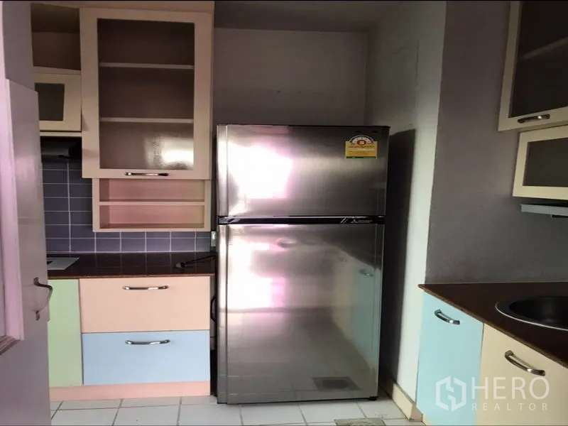 Condominium for rent or sale in Watthana, Bangkok - Compact kitchen with stainless refrigerator and pastel cabinetry.