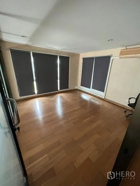 Home Office for rent or sale in Bang Phli, Samut Prakan - Empty room with wooden flooring, blackout roller blinds, and wall air conditioner.