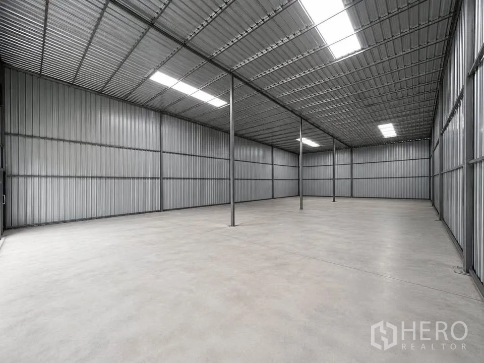 Warehouse for rent in Bang Kapi, Bangkok - Open-plan warehouse interior with high metal roof, steel columns, and smooth concrete floor.