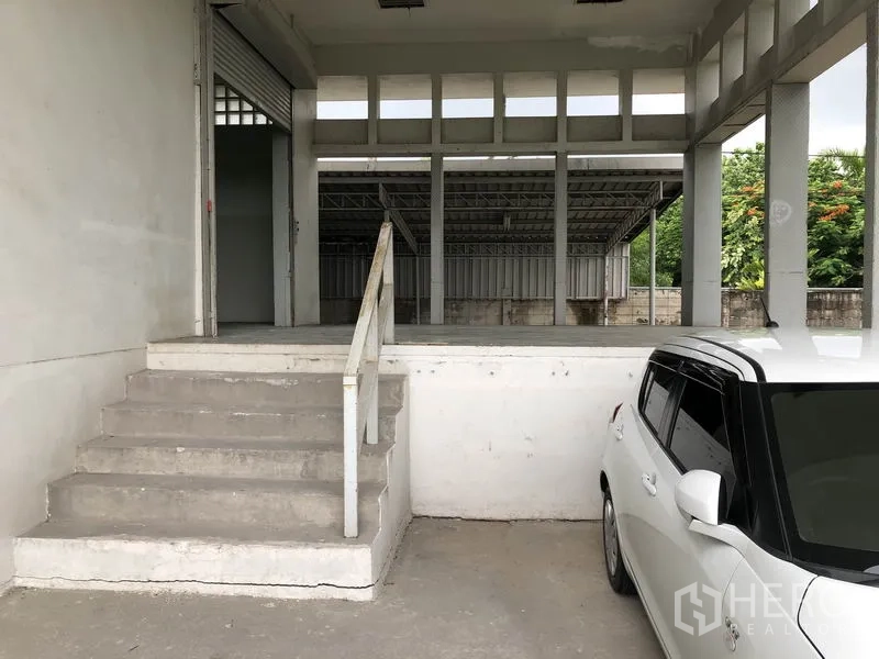 工厂 出租在Lat Krabang, Bangkok - 升高装卸平台与楼梯，旁有卷闸门和停车位