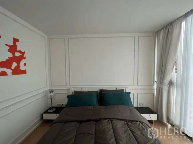 Condominium for rent or sale - Bright bedroom with double bed, teal pillows, side tables and sheer curtains.