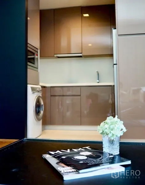 คอนโด ให้เช่าในWatthana, Bangkok - มุมมองจากห้องนั่งเล่นเข้าไปยังครัวแยก พร้อมตู้เก็บของเต็มผนังและตู้เย็น