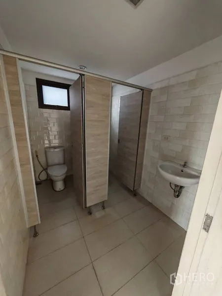 Office Space for rent in Bang Kho Laem, Bangkok - Restroom with multiple cubicles and a wall-mounted sink in neutral tones.