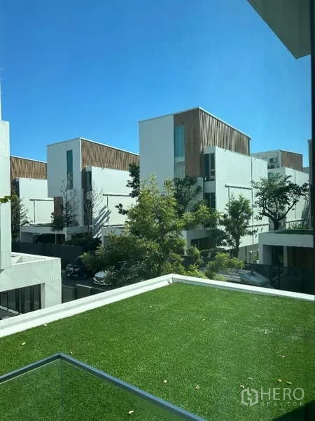 Detached House for rent in Saphan Sung, Bangkok - Balcony with artificial grass overlooking a community of modern houses.