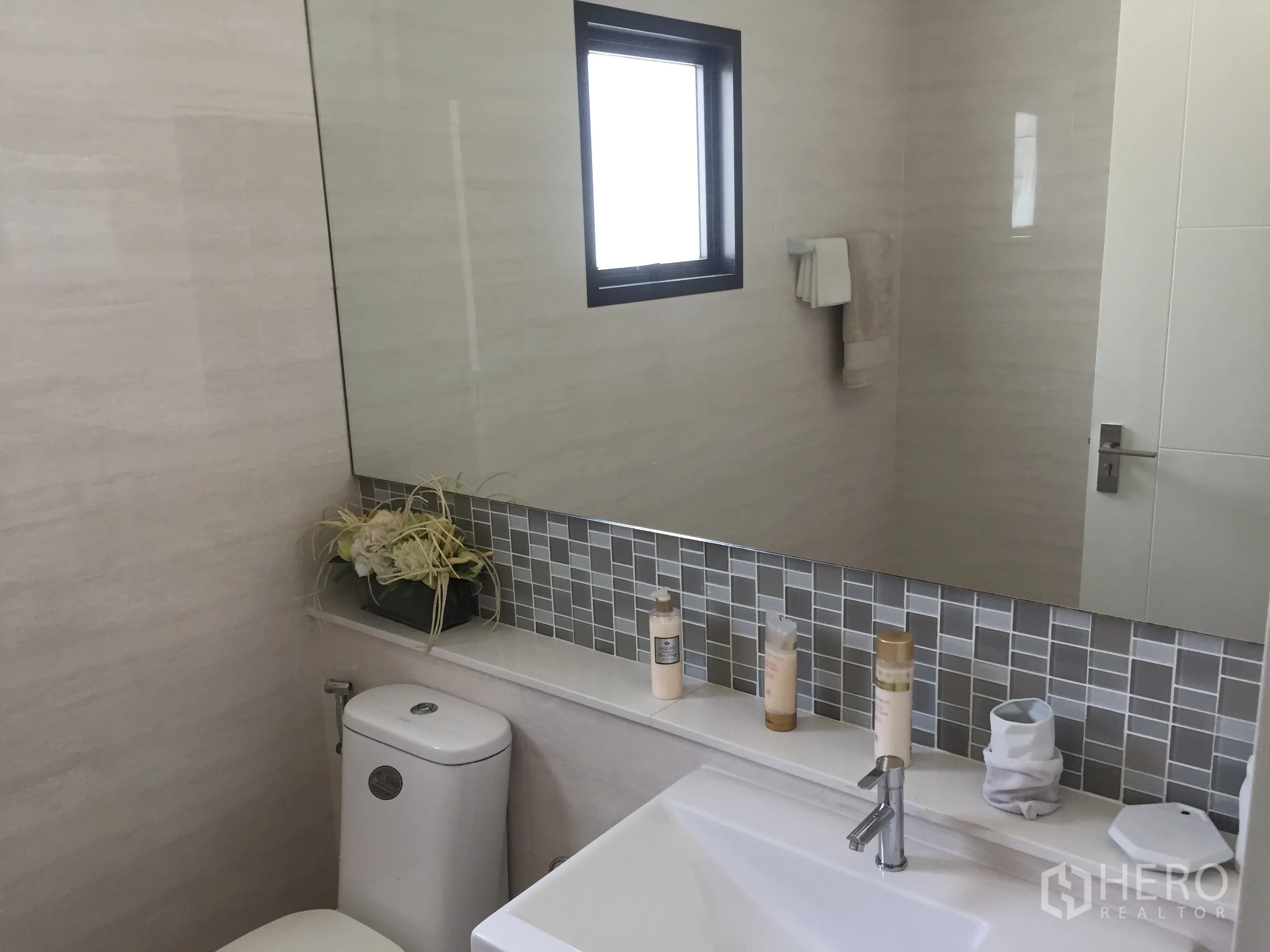 Detached House for sale in Prawet, Bangkok - Modern bathroom with large mirror, mosaic backsplash and white fixtures.