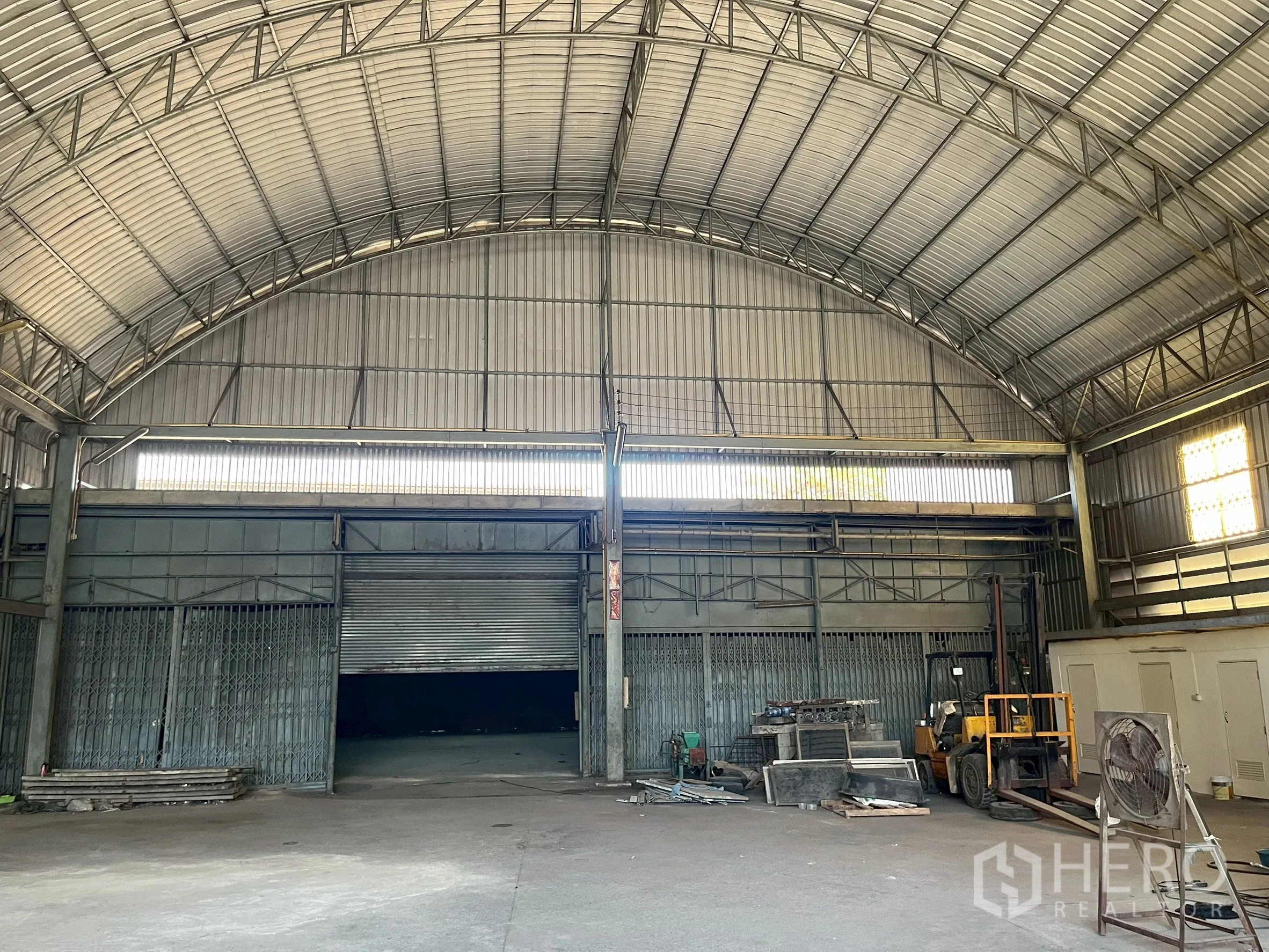 工厂 for rent in Phra Pradaeng, Samut Prakan - 拱形大屋顶下的三樘大型卷帘门与设备区。