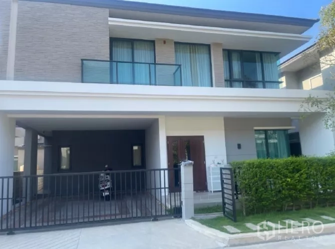 บ้าน ให้เช่าหรือขายในSaphan Sung, Bangkok - หน้าบ้านเดี่ยวสองชั้นสไตล์โมเดิร์น พร้อมโรงจอดรถและรั้วกั้น ในเขตสะพานสูง