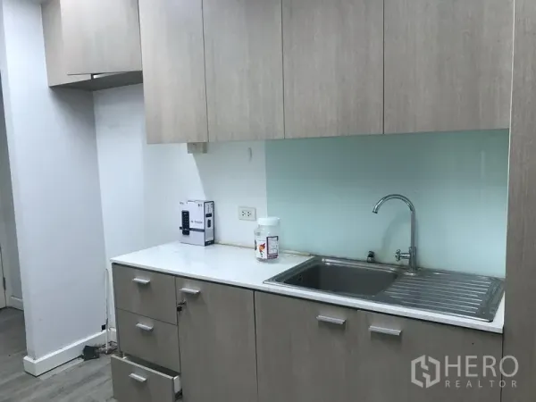 零售空间 出租在Pathum Wan, Bangkok - 茶水间配不锈钢水槽、浅木色橱柜与台面。
