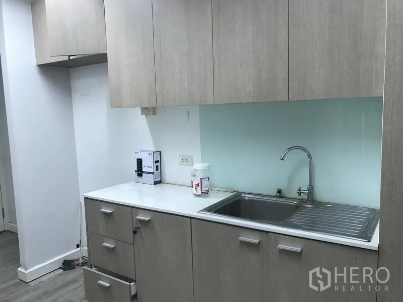 零售空间 出租在Pathum Wan, Bangkok - 茶水间配不锈钢水槽、浅木色橱柜与台面。