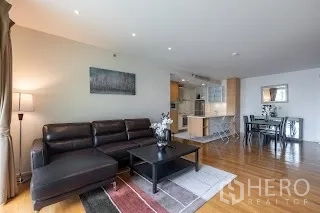 Condominium for rent in Bang Rak, Bangkok - Spacious lounge with L-shaped sofa, coffee table and recessed ceiling lights.