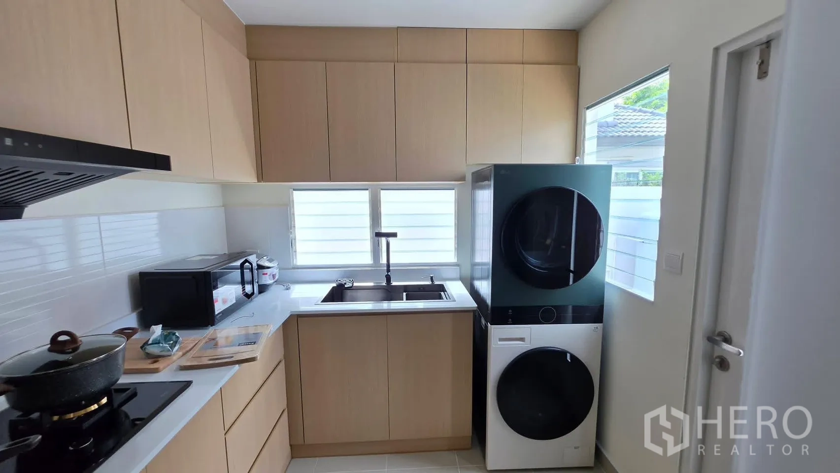 Detached House for rent in Bang Phli, Samut Prakan - Modern kitchen with built-in cabinets, sink, and stacked washer-dryer.