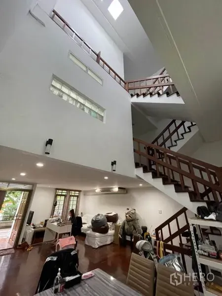 ทาวน์เฮาส์ ให้เช่าในKhlong Toei, Bangkok - ห้องนั่งเล่นเพดานสูงแบบดับเบิลสเปซ มีสกายไลท์และบันไดไม้