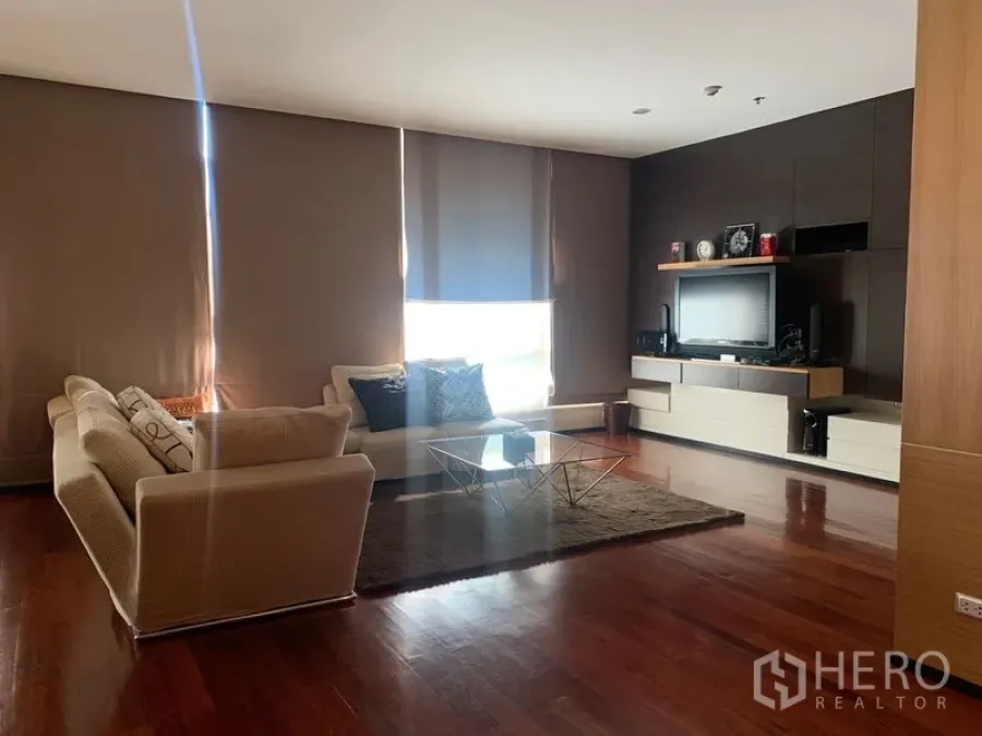 Condominium for rent - Bright living area with natural light, area rug, and built-in media storage.
