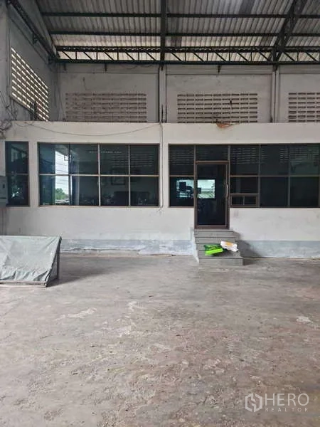 Warehouse for rent in Krathum Baen, Samut Sakhon - Internal office block with large windows inside the warehouse facing a concrete loading area.