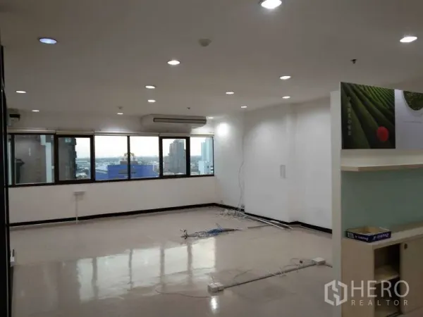 Office Space for rent in Watthana, Bangkok - Wide office space with city-view windows, ceiling downlights, and floor cabling ready for workstations.