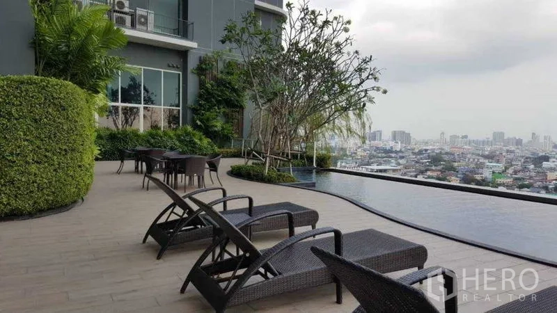 Condominium for rent in Bang Kho Laem, Bangkok - Bright living room with sofa, coffee table, and river-facing balcony.