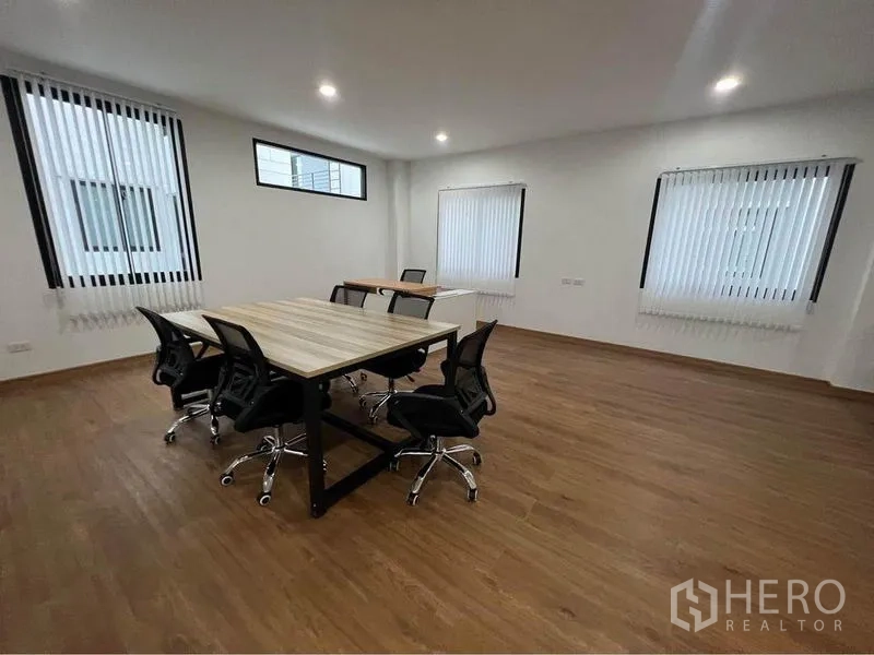 Home Office for rent in Bang Phli, Samut Prakan - Meeting room with two work tables, office chairs, wood floors and multiple windows.