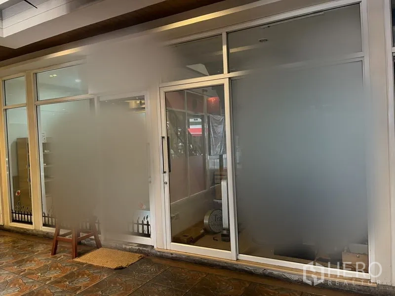 零售空间 出租在Khlong Toei, Bangkok - 零售铺外立面，大幅磨砂玻璃与推拉入口门，吊顶射灯与石质地砖。